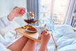 © Goffkein - Waking woman enjoy breakfast in bed in comfortable lazy cozy morning