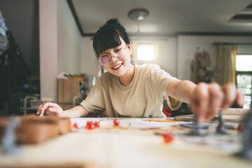 Wall Mural - Young adult asian woman enjoying role playing tabletop and board games