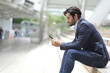 © Thitiporn - Confident businessman with formal suit using smart phone, smiling, talking and checking email.