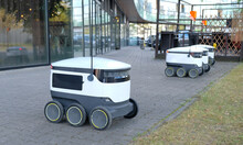 Autonomous Delivery Robot On Tallinn, Estonia. Estonian Company Developing Autonomous Delivery Vehicles. Concept Of Future, Technology, Unmanned Courier Robot.