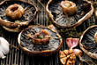 Grilled portobello mushrooms with herbs and garlic on a grill plate, close up view