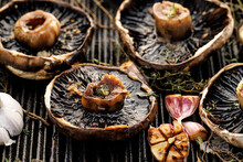 Grilled Portobello Mushrooms With Herbs And Garlic On A Grill Plate, Close Up View