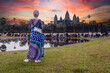 Tourist woman watching sunrise at Angkor Wat temple Siem Reap Cambodia.