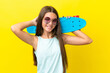 Little caucasian skater girl isolated on yellow background with a skate and looking up