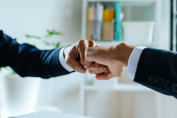 Wall Mural - Negotiation. businessman investor hand to fist bumping and joining hands together after complete business deal in meeting room at home office, partnership, teamwork corporate and financial concept