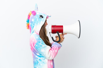 Poster - Little caucasian girl wearing unicorn pajama isolated on white background shouting through a megaphone