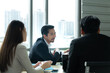 © Wosunan - A group of young Asian entrepreneurs. Top Management is meeting to review stock investment data from the team in a meeting room with natural light