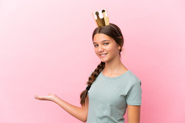 Wall Mural - Little caucasian princess girl isolated on pink background extending hands to the side for inviting to come