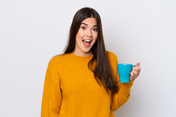 Wall Mural - Young Brazilian woman holding cup of coffee isolated on white background with surprise and shocked facial expression