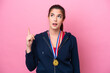 © luismolinero - Young Brazilian sport woman with medals isolated on pink background thinking an idea pointing the finger up