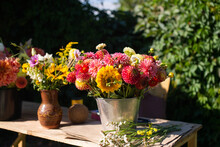 Bouquets Of Autumn Flowers Are On A Wooden Table Outside In A Bucket