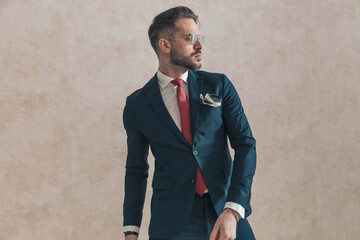 Wall Mural - sexy bearded man wearing navy blue suit with red tie and handkerchief