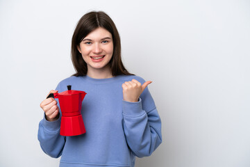 Wall Mural - Young Russian woman holding coffee pot isolated on white background pointing to the side to present a product