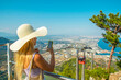 On a sunny summer day, a tourist woman watches the view from the observation terraces on the hill, which can be reached by cable car on Tünektepe Mountain. The upper station was built at an altitude o
