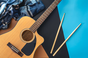 Wall Mural - Music background with guitar and drumsticks, top view.