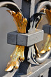metalowy detal architektoniczny, pozłacana metalowa dekoracja, złoty metalowy ornament na bramie,