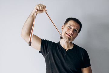 World Mental Health Day. A man in a black t-shirt strangles himself with a rope.