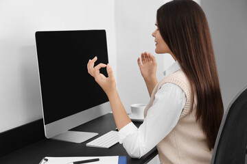 Wall Mural - Young businesswoman meditating at workplace. Zen concept