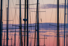 Masts Of Sailboats In The Sky Against A Purple Sunset