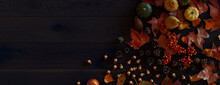 Top Down View Of Dark Wood Tabletop With Leaves, Pumpkins And Pine Cones.