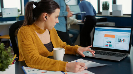 Poster - portrait of startup employee analyzing financial data comparing paper with charts with statistics on
