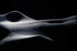Bodyscape of a nude woman stomach backlighting in artistic conversion on black background. Creative backlit.