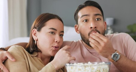 Wall Mural - Scared couple, watching tv and eating popcorn with horror film in the living room in house, jump at television show and surprise at movie in home. Asian man and woman with cinema night together