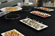 Snacks are ready for presentation on a black-covered table