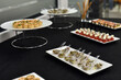 Snacks are ready for presentation on a black-covered table