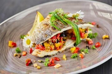 Baked fish with lemon and vegetables. Food from the chef in a restaurant or cafe.