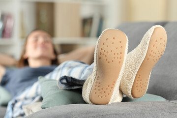 Wall Mural - Woman with slippers resting on a couch at home