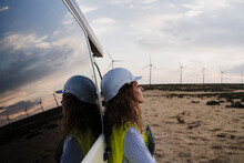 Engineer Wearing Hardhat Leaning On Van At Wind Farm