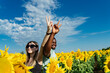 © Westend61 - Smiling woman and man gesturing peace sign in sunflower field