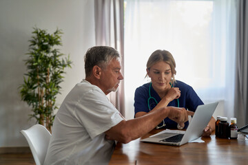 Wall Mural - Caucasian female doctor analyzing medical tests with senior patient at home visit