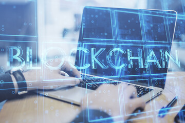 Aufkleber - Close up of businessman hands using laptop keyboard with creative blue cubes blockchain text hologram. Technology and information concept. Double exposure.