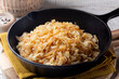 Quick Pan fried Sauerkraut or Crauti. Finely cut white cabbage cooked with fried onion and white wine. Close-up.