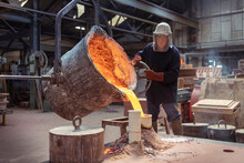 Worker Pouring Molten Brass Into Large Mold In Brass Foundry