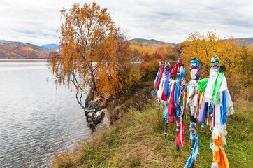 Wall Mural - baikal lake in september. natural landmark cape shamansky. colored tourist ribbons and buddhist pray