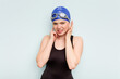 © Asier - Young caucasian swimmer woman isolated on blue background covering ears with hands.