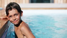 4k Video Portrait Of Smiling Handsome Boy In Swimming Pool, Child Enjoying Swimming In Summer In Pool. Vacation Hotel Concept.