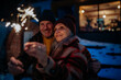 © Halfpoint - Happy senior couple celebrating new year with sparklers, enjoying winter evening.