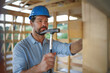 © Halfpoint - Construction worker working with hammer on wooden frame, diy eco-friendly homes concept.