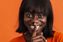 Portrait Of Young Beautiful Smiling African Woman Showing Silence Gesture