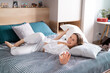 © arthurhidden - Happy caucasian woman fights with a white pillow, smiles broadly, glad to have pillow fight with husband