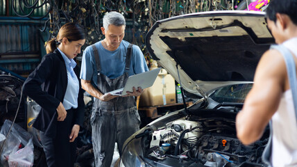 Wall Mural - Asian young woman customer talking with owner and mechanic worker at car repair service and auto store shop.