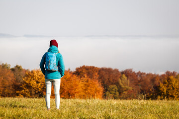 Autumn hiking. Woman with sports clothing trekking in nature