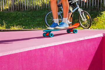 Wall Mural - Legs of teenage boy skate riding a skateboard at skatepark