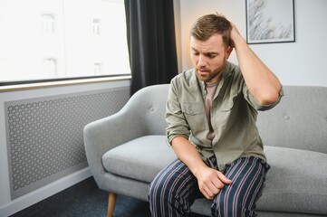 Wall Mural - Man having a headache at home