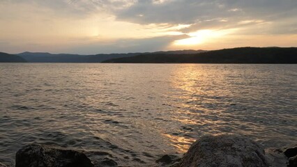 Canvas Print - Summer sunset or sunrise landscape over Danube river horizon. Sunlight reflection on water surface. Mountain scenery in background. 