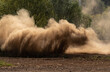 Dust and sand rising up the road from the wheels of the car. Sandstorm, dust up